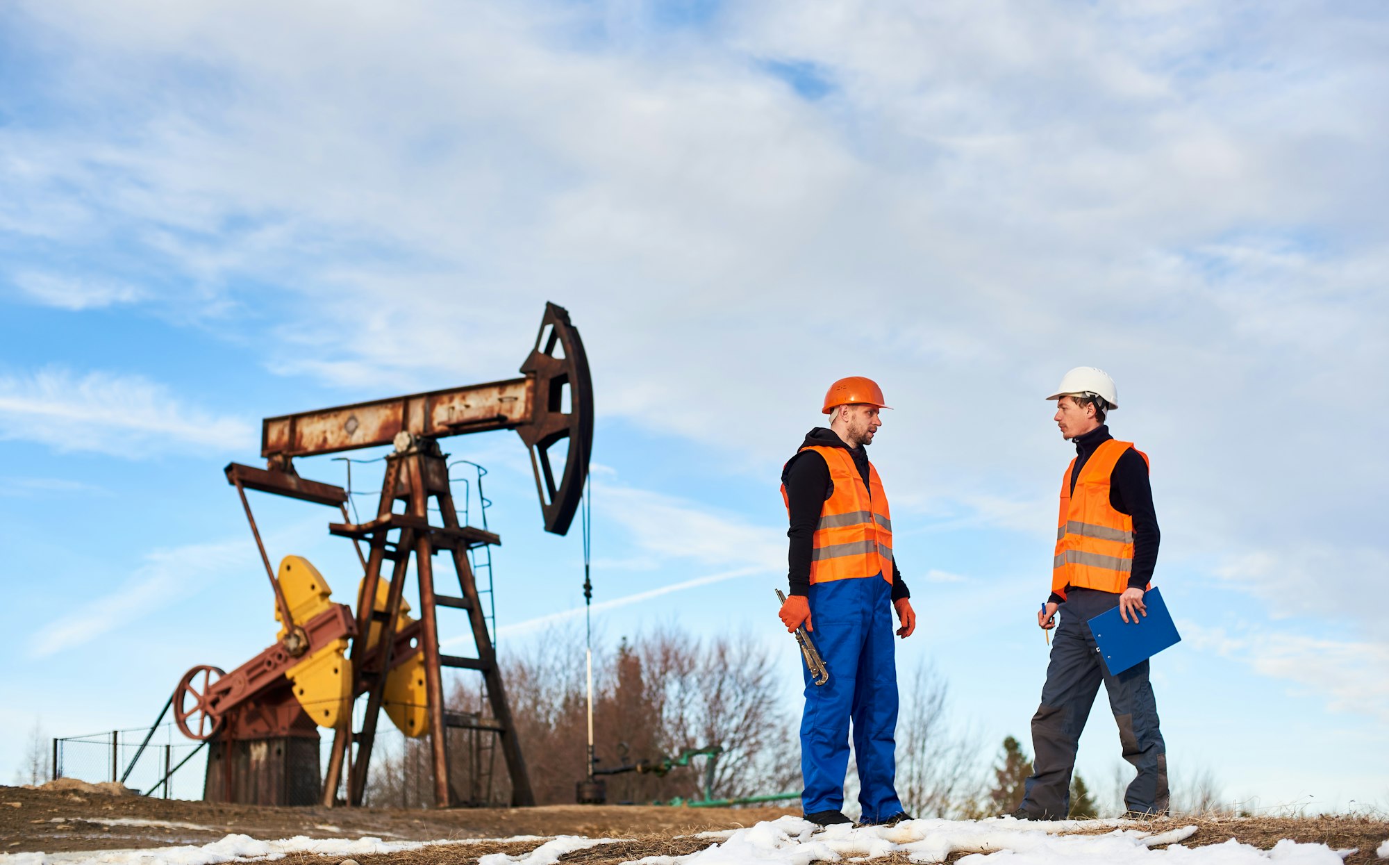 Petroleum operators talking at oil field.
